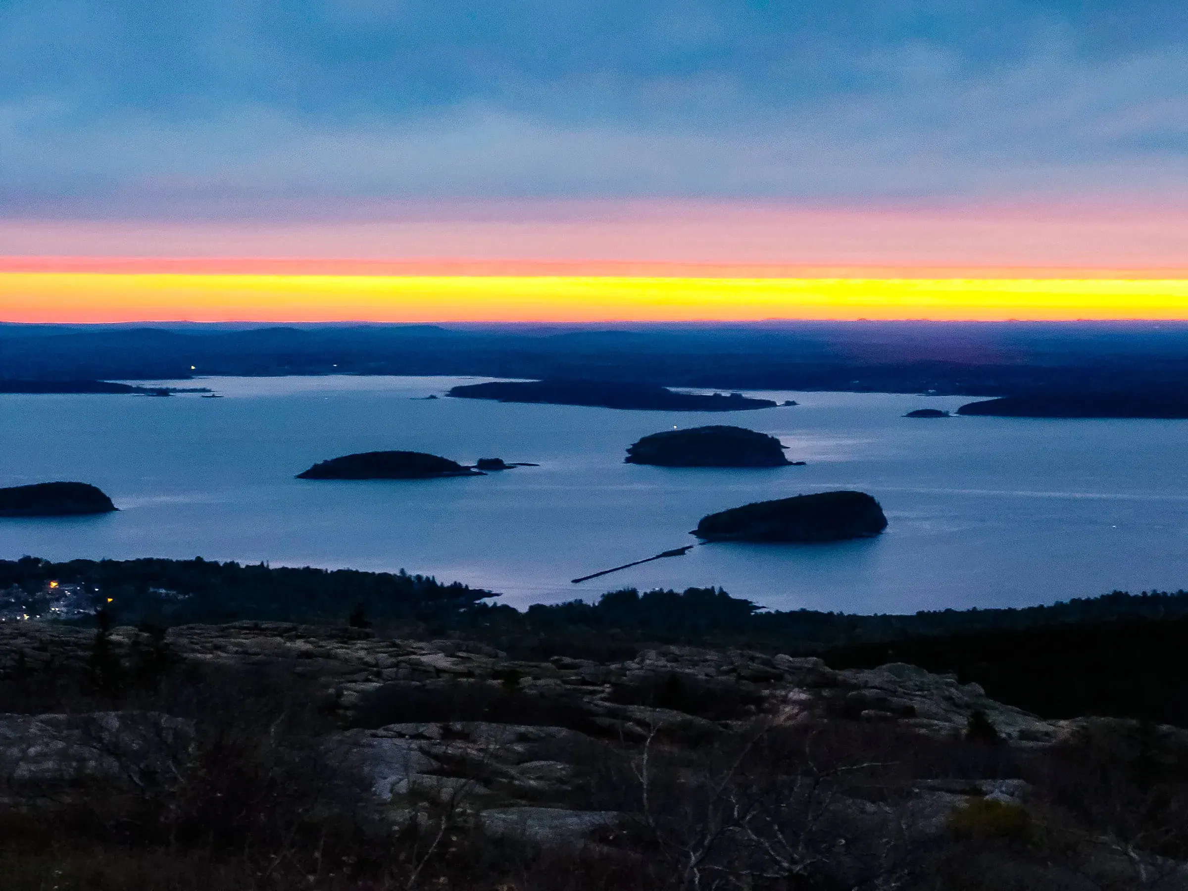 Sunrise light spreading over islands from Cadillac Mountain