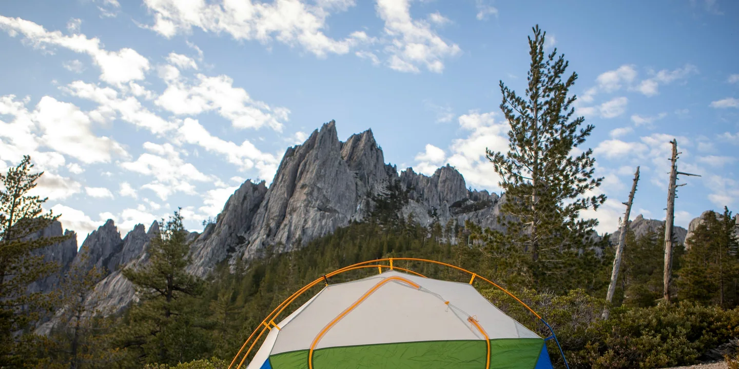 A small tent pitched carefully on a rocky, durable forest campsite