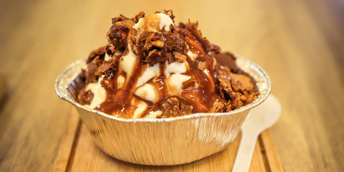 A chocolate crunch dessert served in a small foil bowl